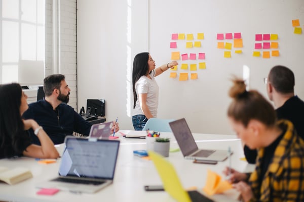 Woman presents sticky notes about changing attitudes towards Quarterly Business Reviews